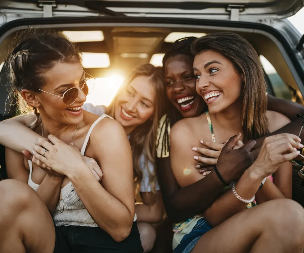 4 women sitting in the car and laughing together