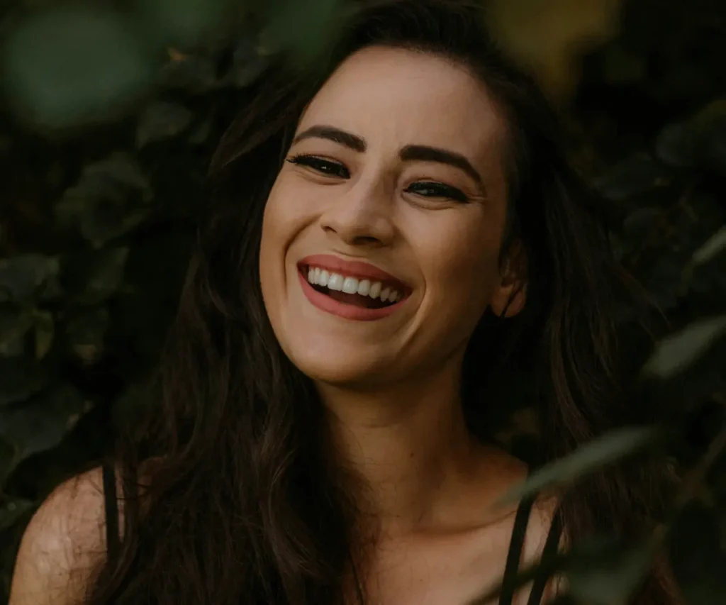 a woman with long dark hair smiling at the camera